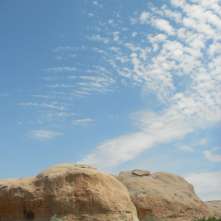 Rock formations, dry arid land, wispy clouds